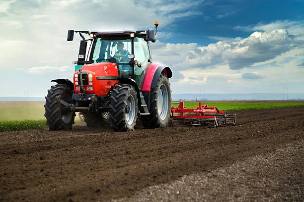 Red tractor working a ploughed field